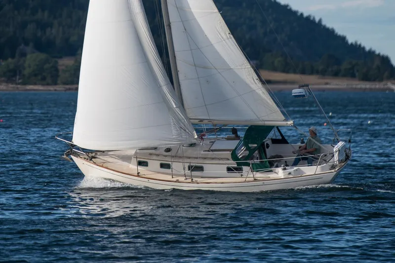 Slide: The Image of Sailboat "Morris Linda 28" from 1988 sailing on a calm sea with scenic background. - 1