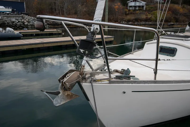 Slide: The Image of 1988 Morris Linda 28 sailboat docked, featuring anchor and calm water reflection. - 10