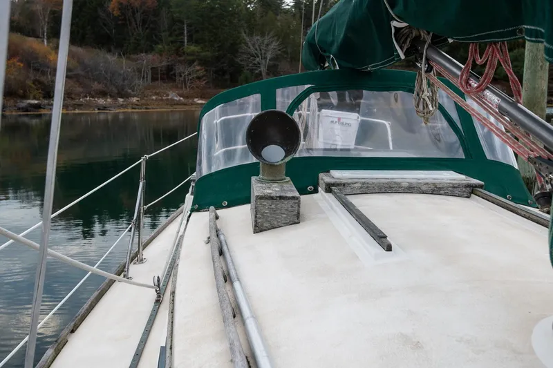 Slide: The Image of Sailboat deck view, Morris Linda 28, 1988 model, with green canopy and serene water backdrop. - 14