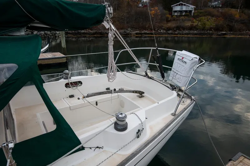 Slide: The Image of 1988 Morris Linda 28 sailboat docked, featuring a clean deck and green canopy. - 15
