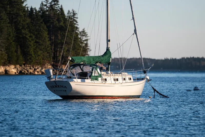 Slide: The Image of Sailboat "Morris Linda 28" from 1988 anchored in a serene coastal setting. - 2