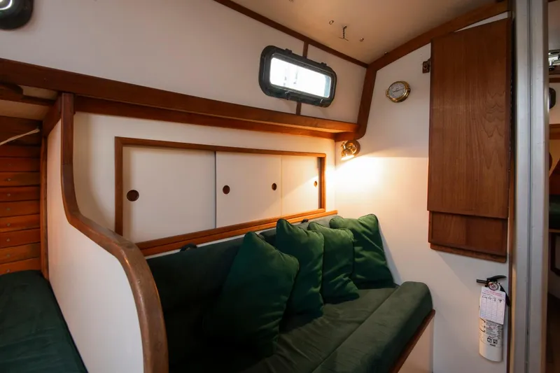 Slide: The Image of Cozy interior of 1988 Morris Linda 28 sailboat with green cushions and wooden accents. - 21