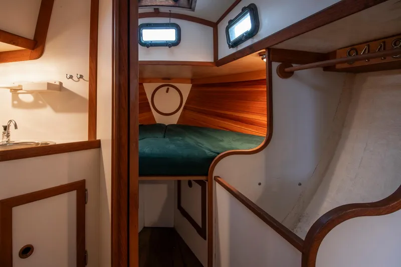Slide: The Image of Cozy cabin interior of 1988 Morris Linda 28 sailboat with wood accents and green bedding. - 22