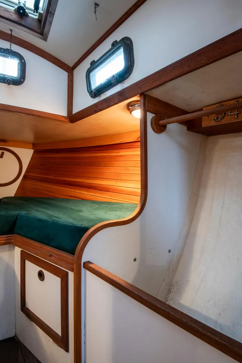 Slide: The Image of Cozy cabin interior of 1988 Morris Linda 28 sailboat with wooden accents and green bedding. - 25