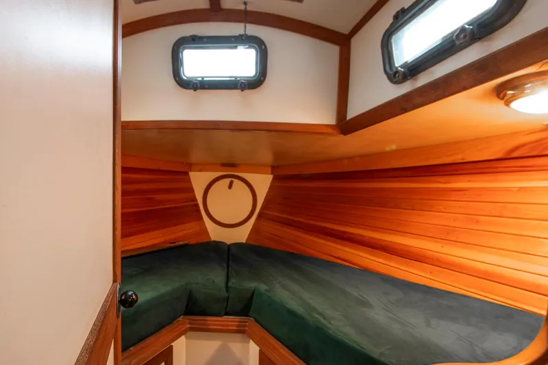 Slide: The Image of Cozy cabin interior of 1988 Morris Linda 28 sailboat with wooden paneling and green cushions. - 27