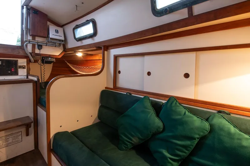 Slide: The Image of Cozy interior of 1988 Morris Linda 28 sailboat with green cushions and wooden accents. - 29