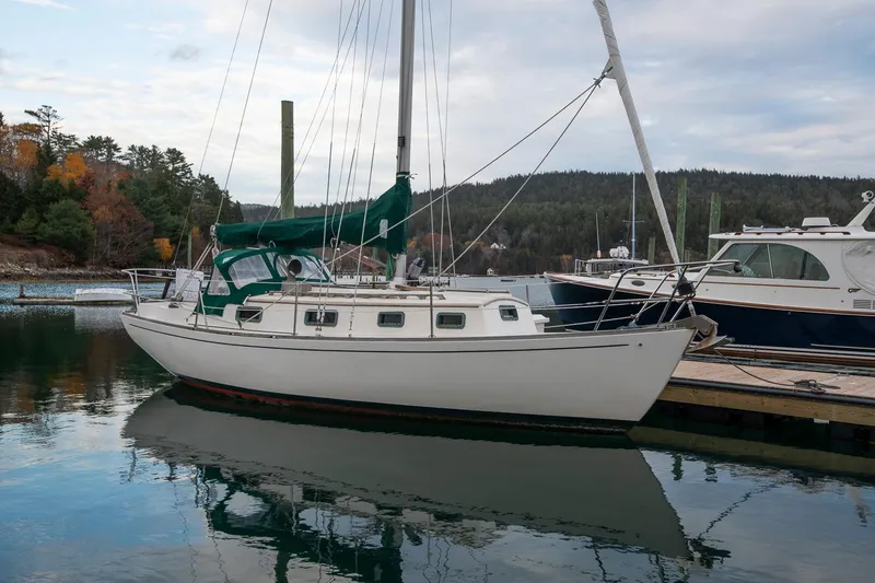 Slide: The Image of Sailboat Morris Linda 28, 1988 model, docked in a serene marina setting. - 9