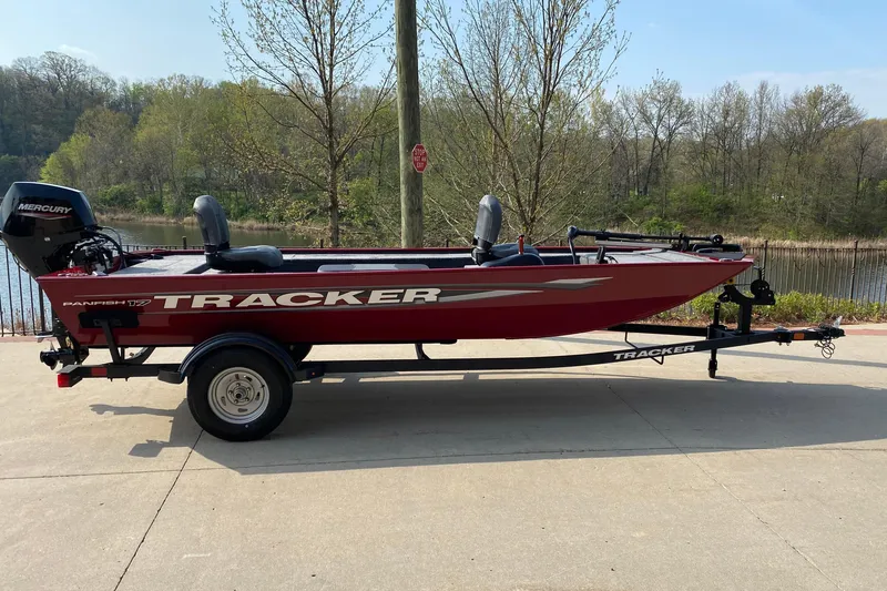 The Image of 2025 Tracker Panfish 17 boat on trailer, parked near a scenic lake. - 0