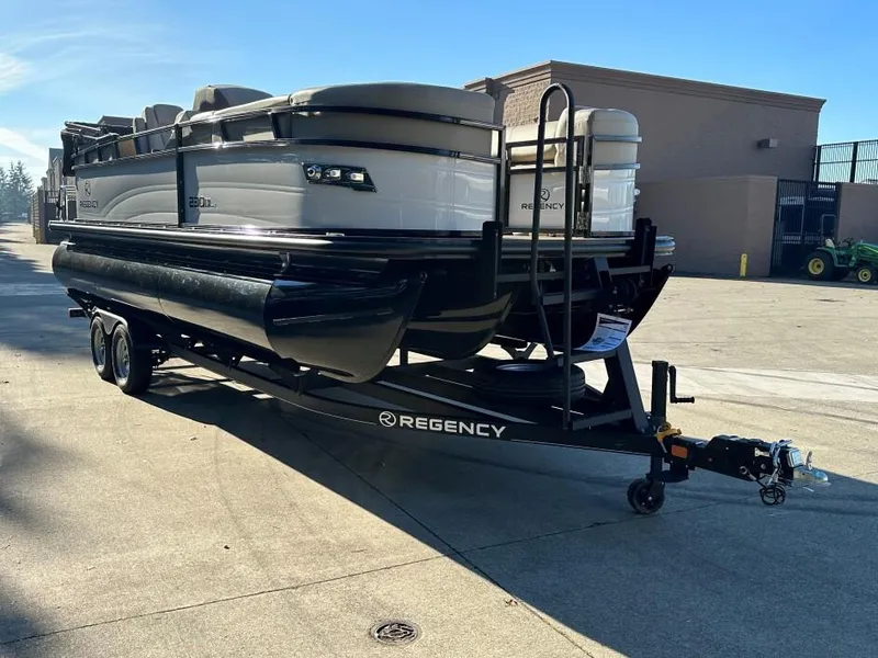Slide: The Image of 2024 Regency 230 DL3 pontoon boat on trailer in outdoor setting. - 3