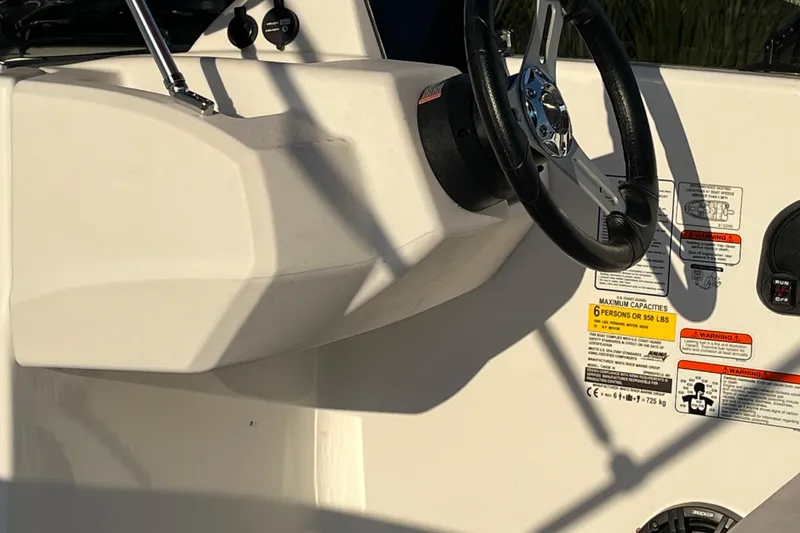 Slide: The Image of 2025 Tahoe T16 boat dashboard with steering wheel and capacity warnings. - 6