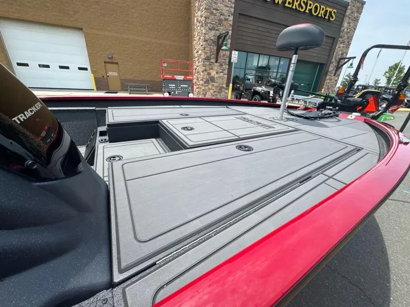 Slide: The Image of 2025 Tracker Savage 215 boat deck at a dealership, showcasing storage compartments and sleek design. - 2