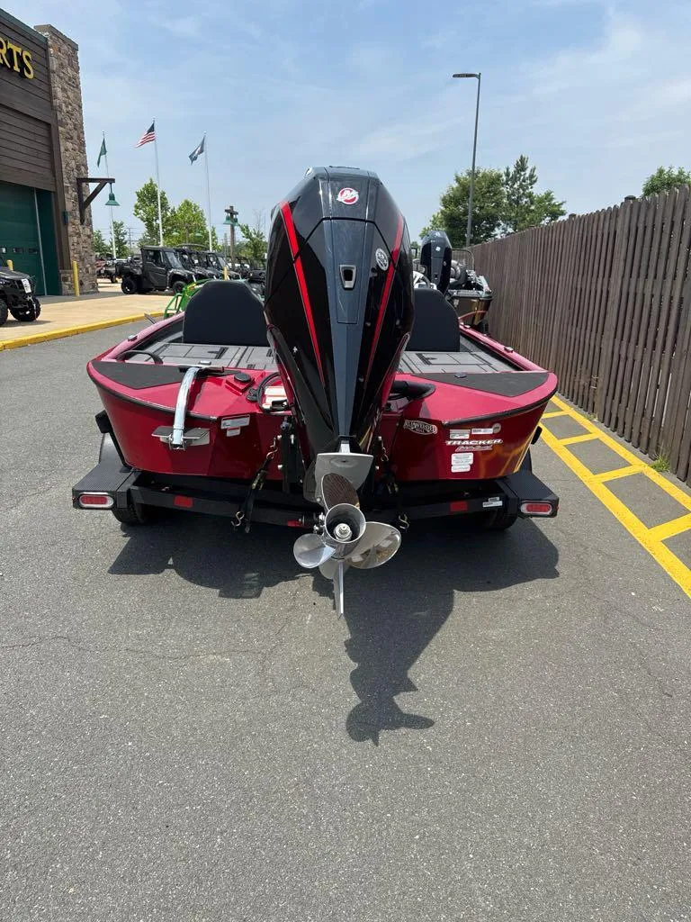 Slide: The Image of 2025 Tracker Savage 215 boat, red exterior, parked outdoors on a sunny day. - 4