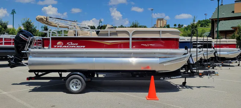 The Image of 2025 Sun Tracker Party Barge 18 DLX pontoon boat on trailer in parking lot. - 0