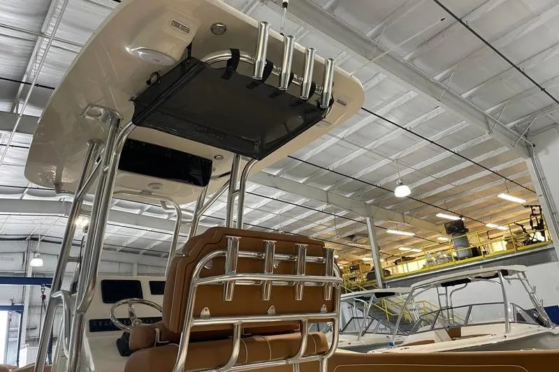 Slide: The Image of 2025 Key West 239 FS boat interior with seating and rod holders in a showroom. - 17