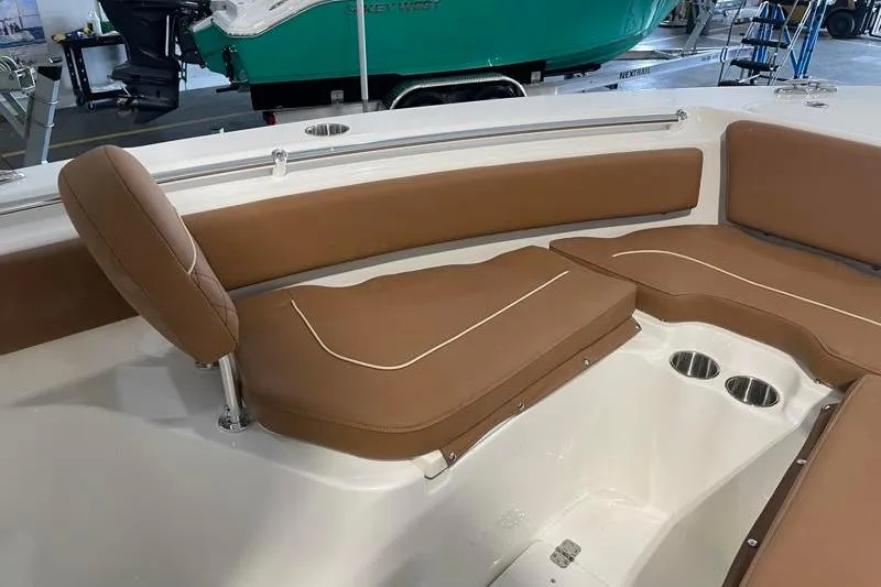 Slide: The Image of 2025 Key West 239 FS boat interior with brown cushioned seating and cup holders. - 21