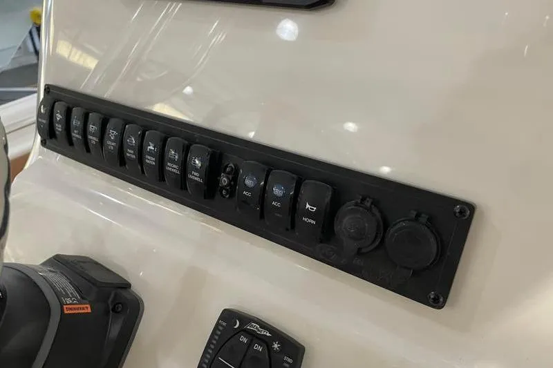 Slide: The Image of Control panel of 2025 Key West 239 FS boat with multiple switches and dials. - 35