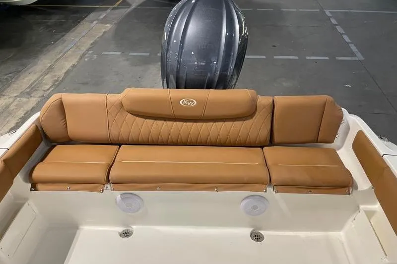 Slide: The Image of 2025 Key West 239 FS boat with tan leather seating and visible engine in a garage. - 39