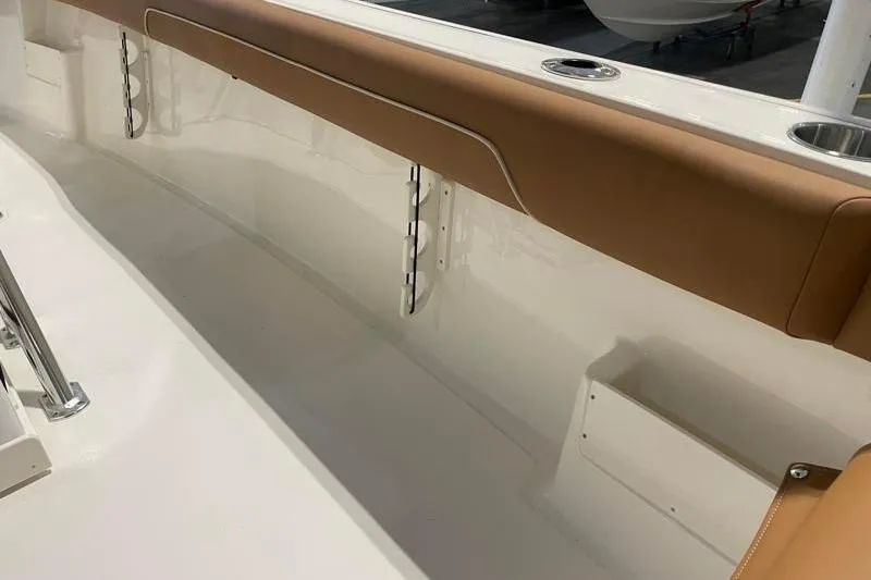 Slide: The Image of 2025 Key West 239 FS boat interior with tan upholstery and stainless steel cup holders. - 43