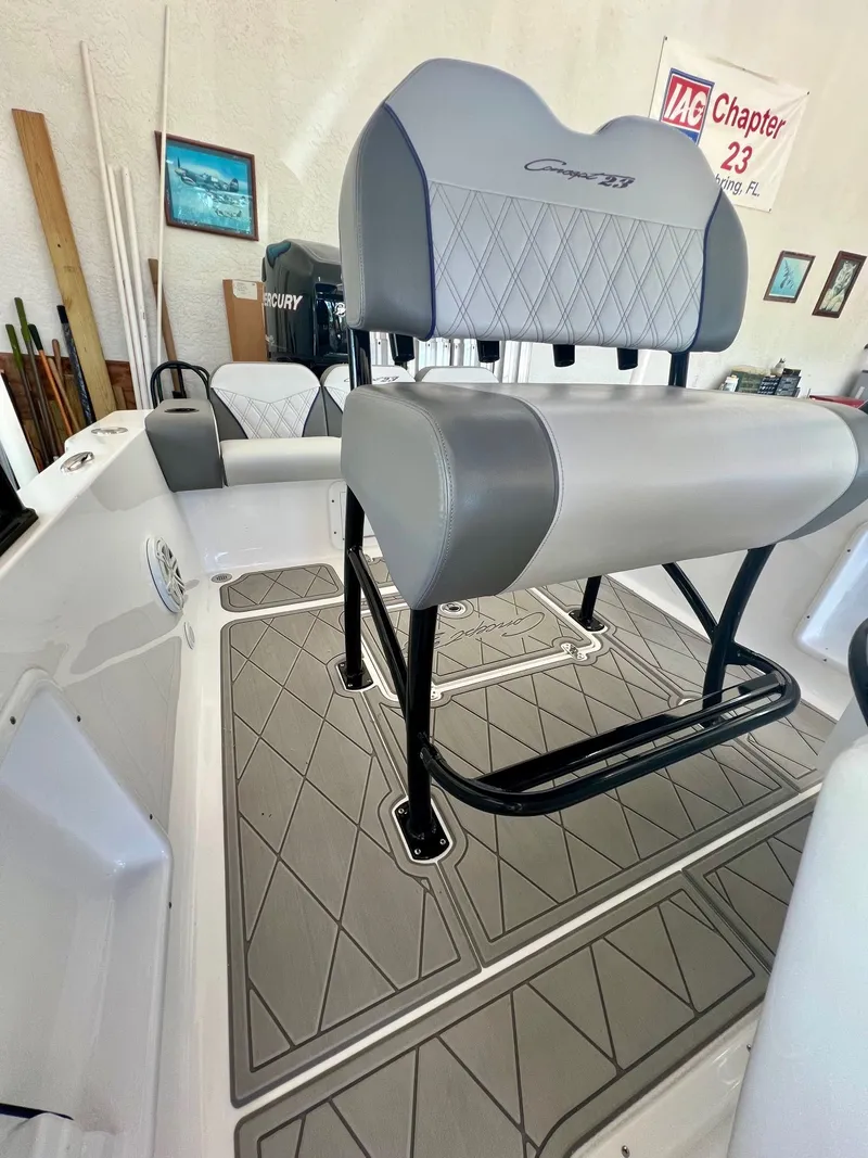 Slide: The Image of Interior of a 2018 Concept 23 boat with gray upholstered seats. - 12