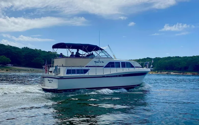 Slide: The Image of 1985 Chris-Craft 381 Catalina cruising on a scenic lake under a clear blue sky. - 1