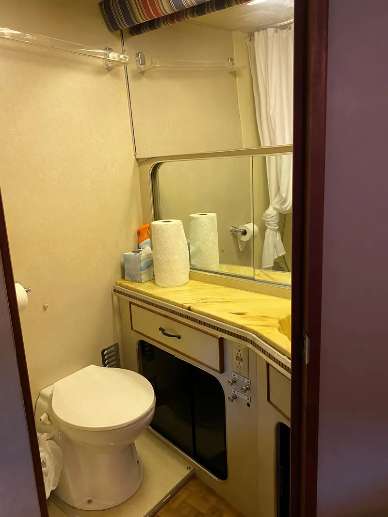 Slide: The Image of 1985 Chris-Craft 381 Catalina bathroom with toilet, mirror, and countertop essentials. - 11