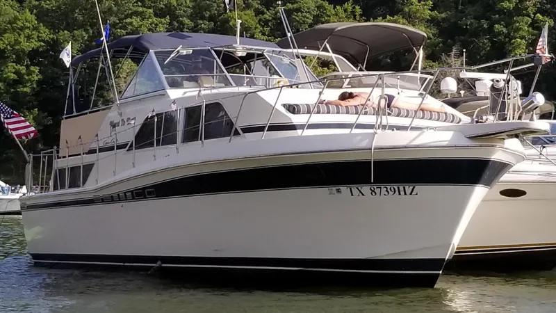 Slide: The Image of 1985 Chris-Craft 381 Catalina yacht docked on a sunny day, surrounded by lush greenery. - 3
