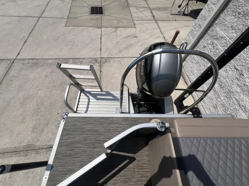 Slide: The Image of 2022 Bennington 22 LS boat with motor and ladder on concrete surface. - 10