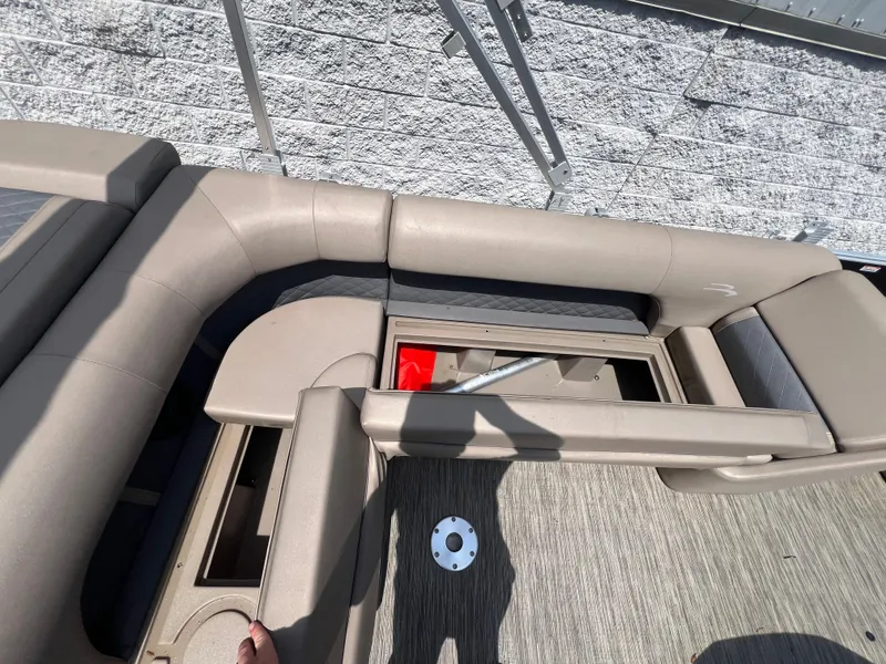 Slide: The Image of 2022 Bennington 22 LS boat interior with beige seating and storage compartments. - 12