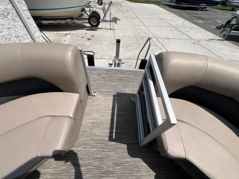 Slide: The Image of 2022 Bennington 22 LS pontoon boat interior with beige seating and open gate. - 18