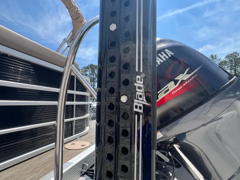 Slide: The Image of 2022 Bennington 22 LS boat with Yamaha engine and Blade power pole, under clear blue sky. - 25