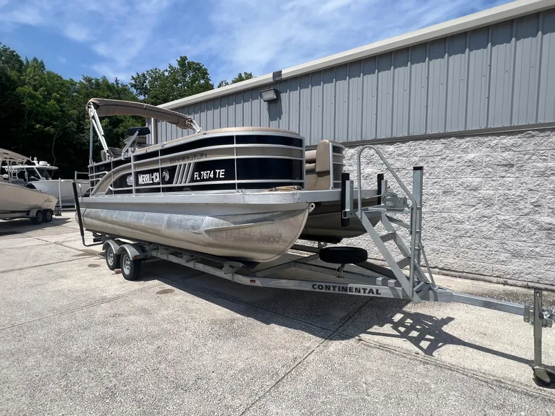 Slide: The Image of 2022 Bennington 22 LS pontoon boat on trailer, parked outdoors. - 3