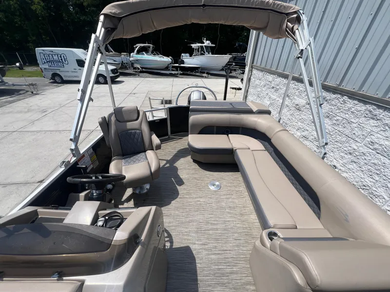 Slide: The Image of 2022 Bennington 22 LS pontoon boat interior with beige seating and canopy. - 6