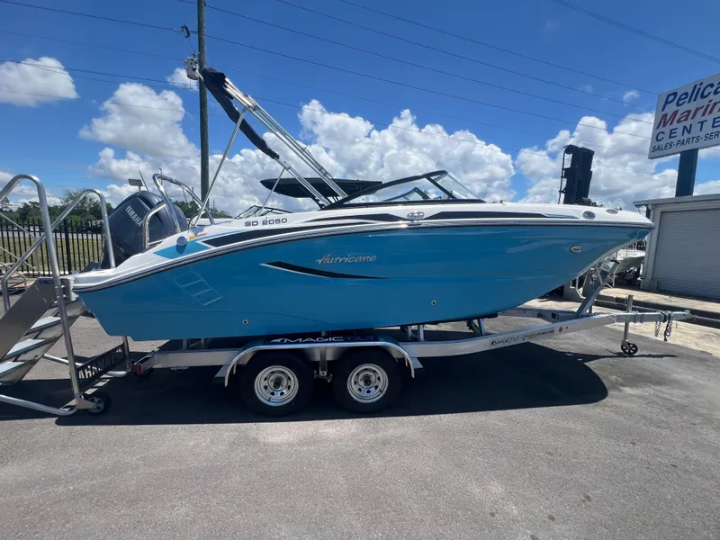 Slide: The Image of 2025 Hurricane SunDeck Sport 2050 OB boat on trailer, blue hull, sunny day, Pelican Marine Center. - 2