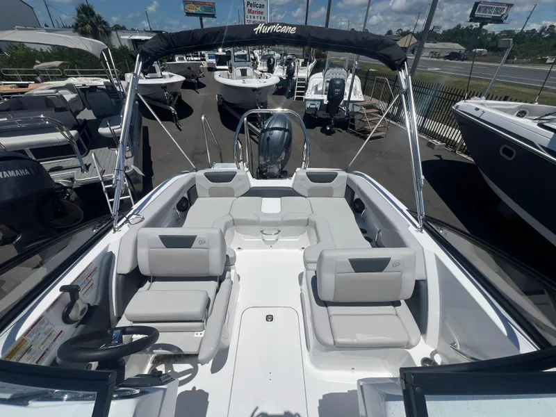 Slide: The Image of 2025 Hurricane SunDeck Sport 2050 OB boat with spacious seating and sleek design at a marina. - 7