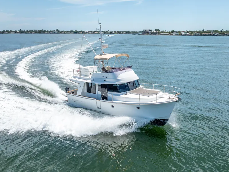 Slide: The Image of 2015 Beneteau Swift Trawler 34 cruising on open water, creating a wake behind. - 18