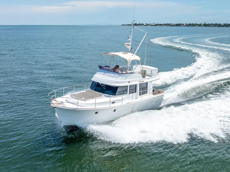 Slide: The Image of 2015 Beneteau Swift Trawler 34 cruising on open water, creating a wake. - 20