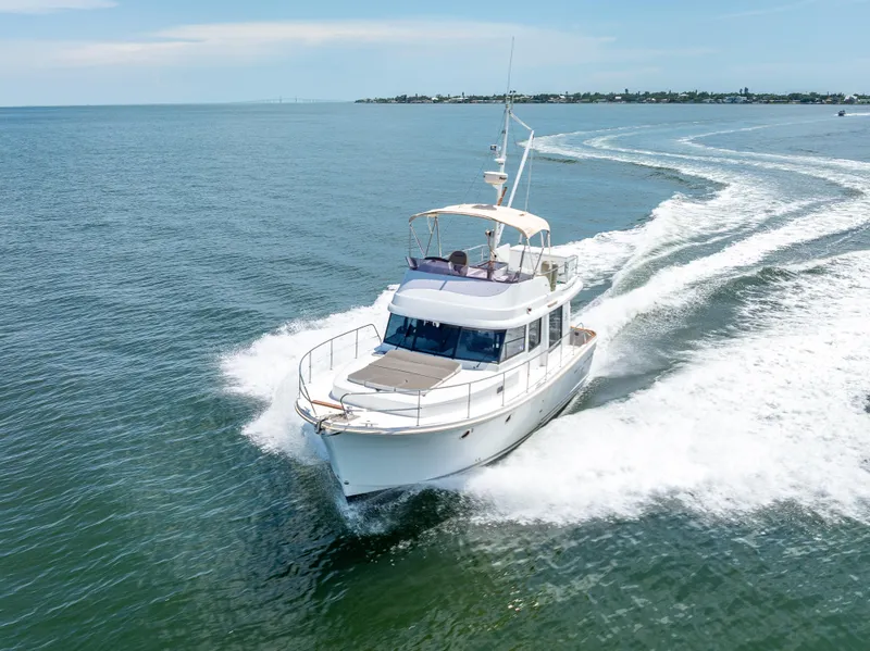 Slide: The Image of 2015 Beneteau Swift Trawler 34 cruising on open water, creating a wake. - 21