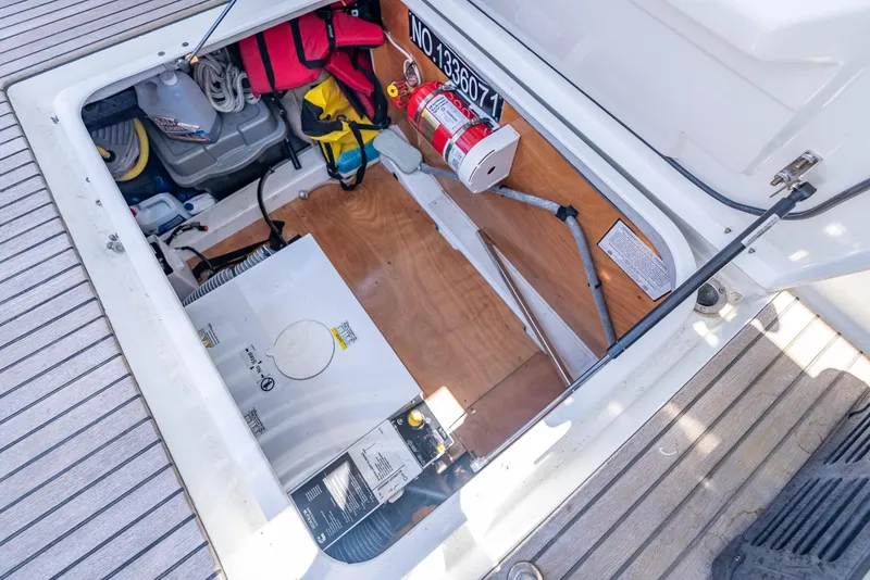 Slide: The Image of Open storage compartment on 2015 Beneteau Swift Trawler 34, showing equipment and safety gear. - 22