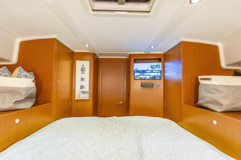 Slide: The Image of 2015 Beneteau Swift Trawler 34 cabin interior with wood paneling and cozy bedding. - 28