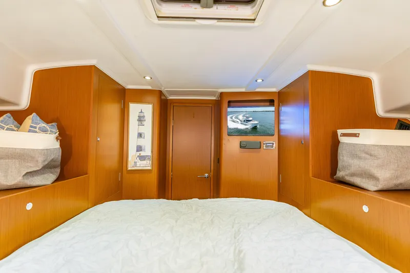 Slide: The Image of 2015 Beneteau Swift Trawler 34 cabin interior with wood paneling and cozy bedding. - 29