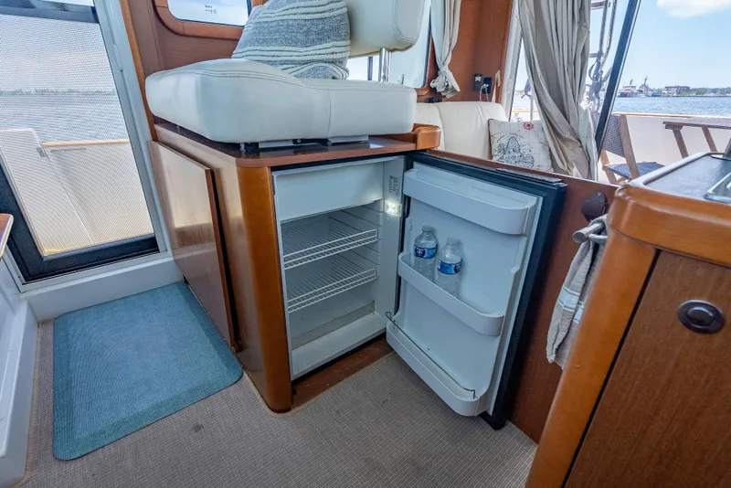 Slide: The Image of Interior of 2015 Beneteau Swift Trawler 34 with open mini fridge and seating area. - 35
