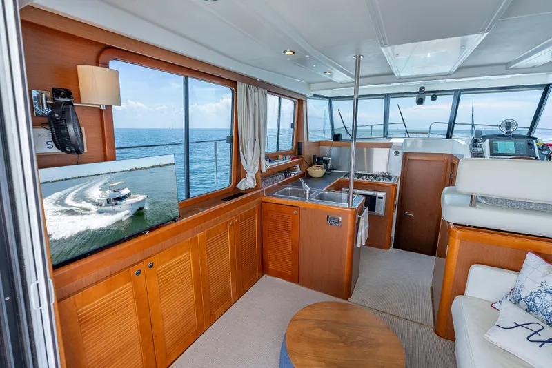 Slide: The Image of Interior of 2015 Beneteau Swift Trawler 34, featuring kitchen, seating, and ocean view. - 47