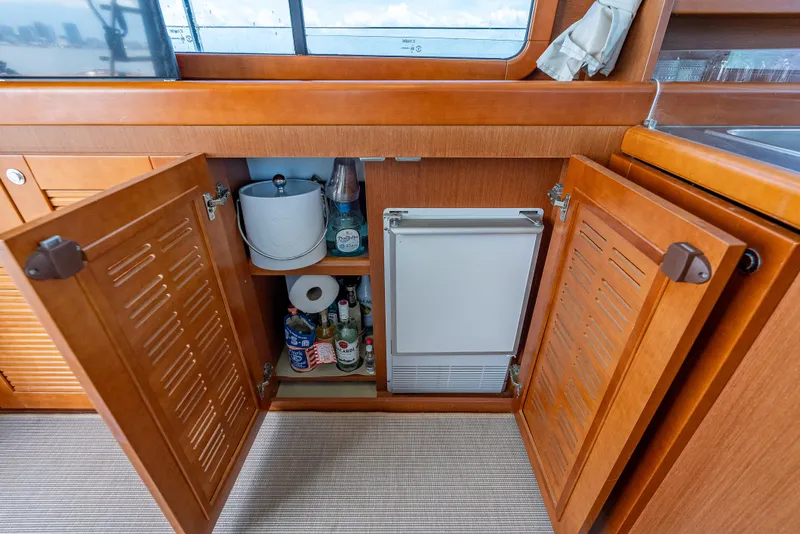Slide: The Image of Interior of 2015 Beneteau Swift Trawler 34 with open cabinet and mini fridge. - 49