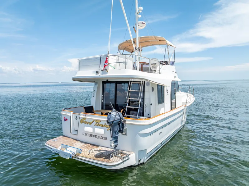 Slide: The Image of 2015 Beneteau Swift Trawler 34 on calm waters, rear view, sunny day. - 8