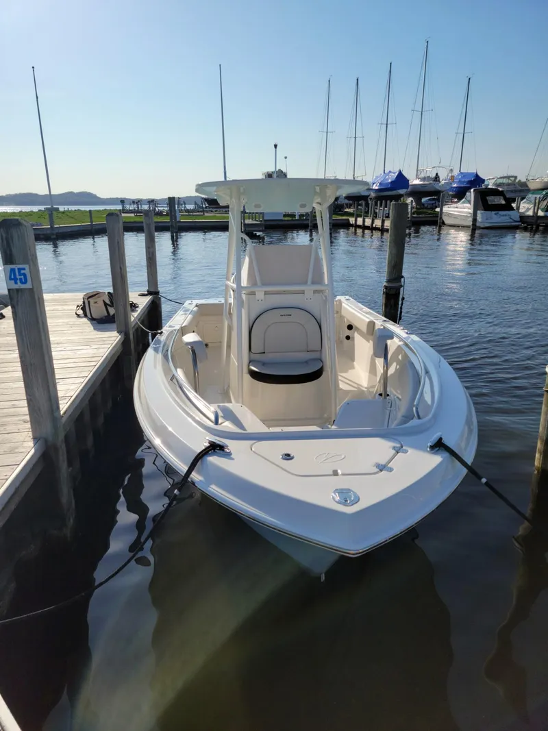 Slide: The Image of 2022 Sailfish 220 CC boat docked at marina, clear sky, calm water. - 5