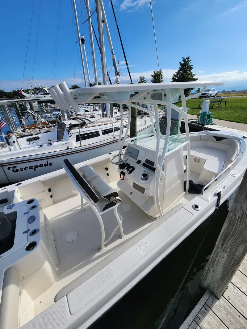 Slide: The Image of 2022 Sailfish 220 CC boat docked, featuring a sleek design and modern console. - 6