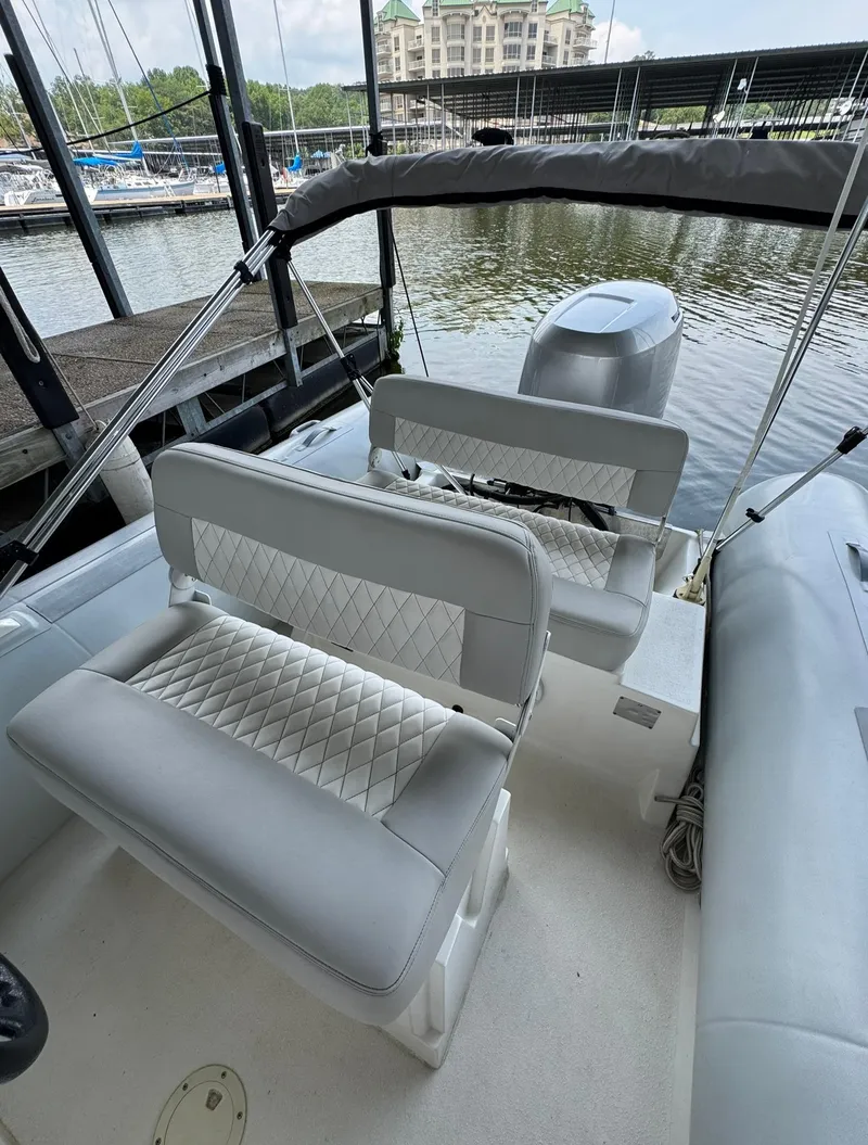 Slide: The Image of 2004 AB Inflatables 570 VST boat interior with seating, docked at marina. - 14