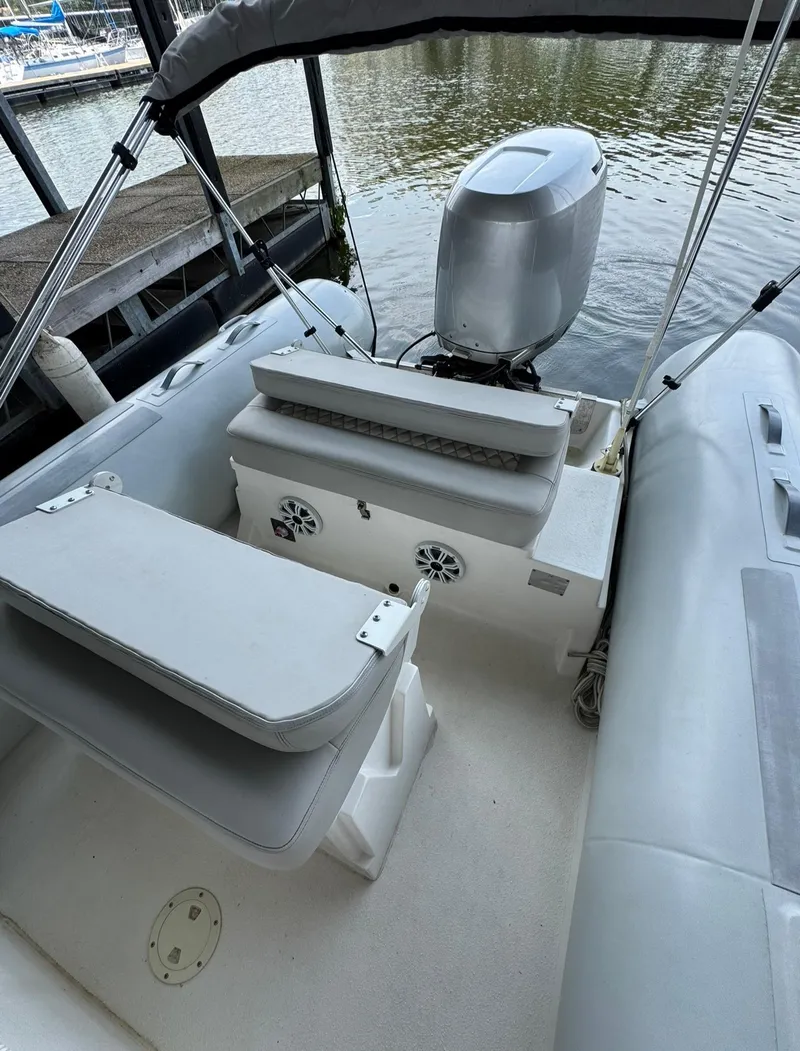 Slide: The Image of 2004 AB Inflatables 570 VST boat with outboard motor, docked on calm water. - 15