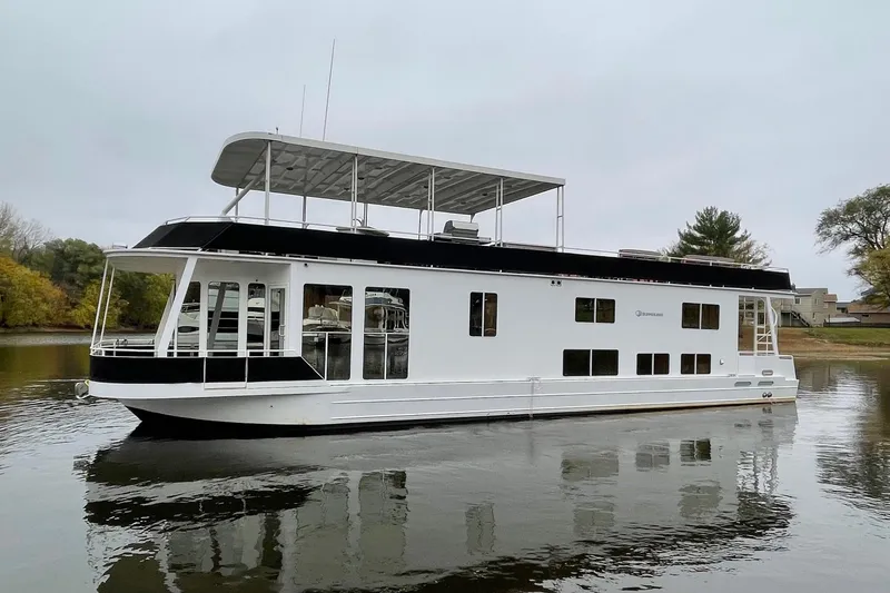 The Image of 2007 Skipperliner 640 houseboat on calm water, featuring a sleek white and black design. - 0