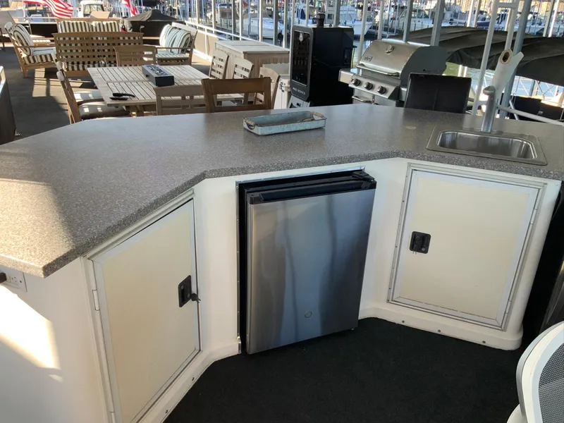 Slide: The Image of Outdoor kitchen on 2007 Skipperliner 640 with fridge, sink, and seating area. - 15